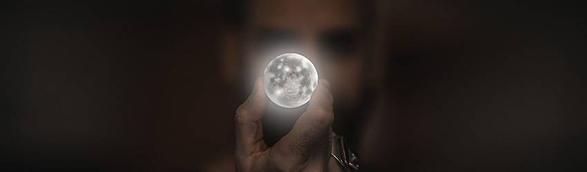 Person holding a full moon in front of their face.