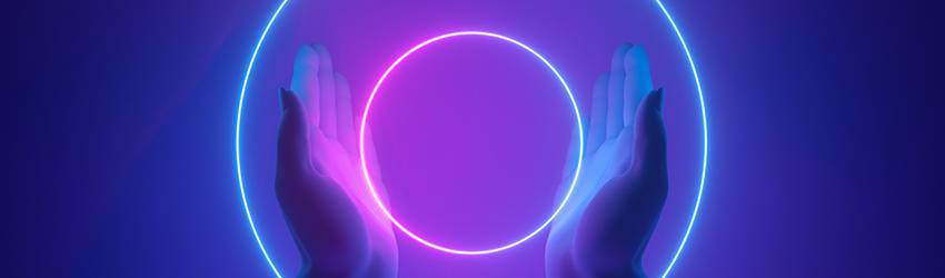 A person holds two rings of neon purple lights between their hands.